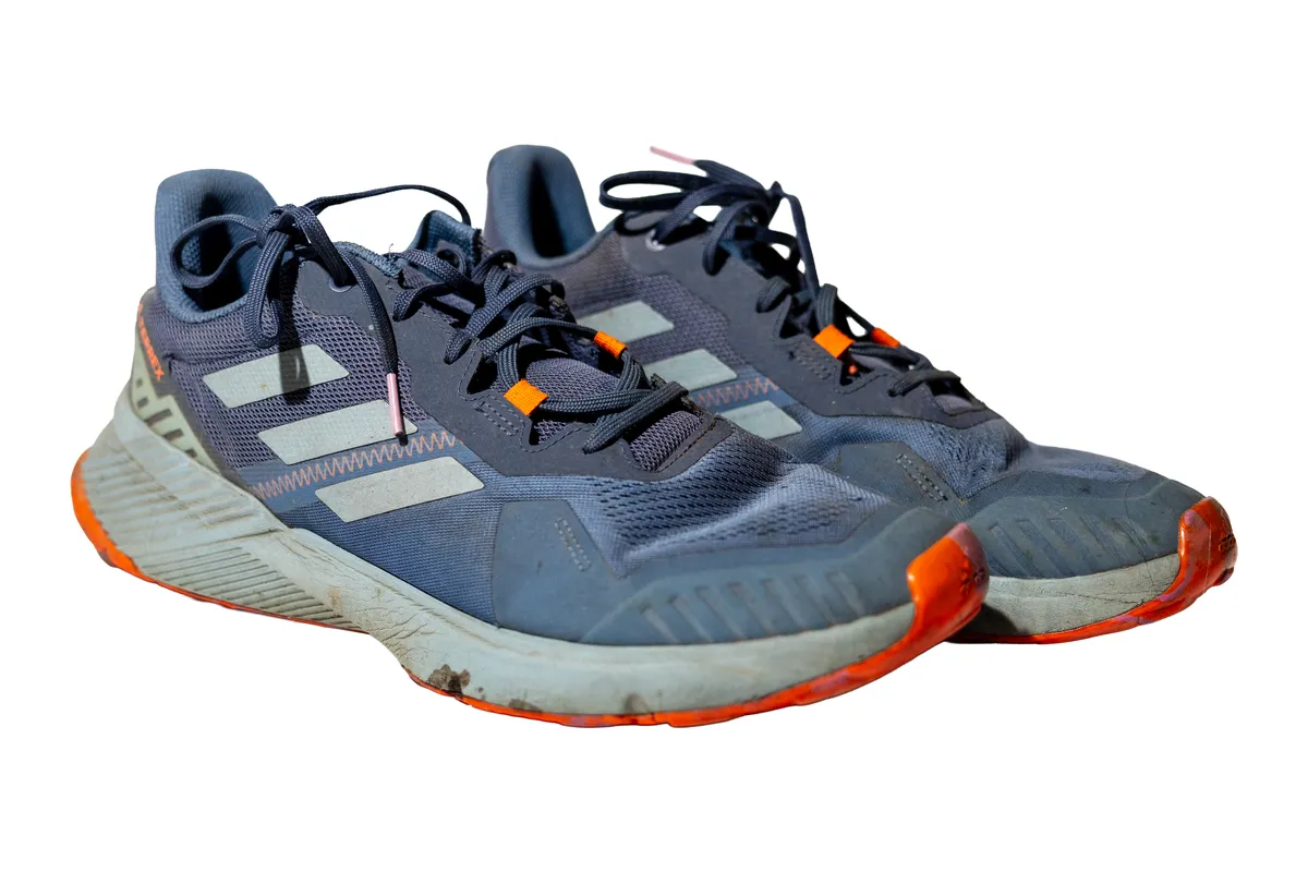 Adidași Adidas albaștri înainte de curățare: tălpi gri pline de noroi, fețe prăfuite